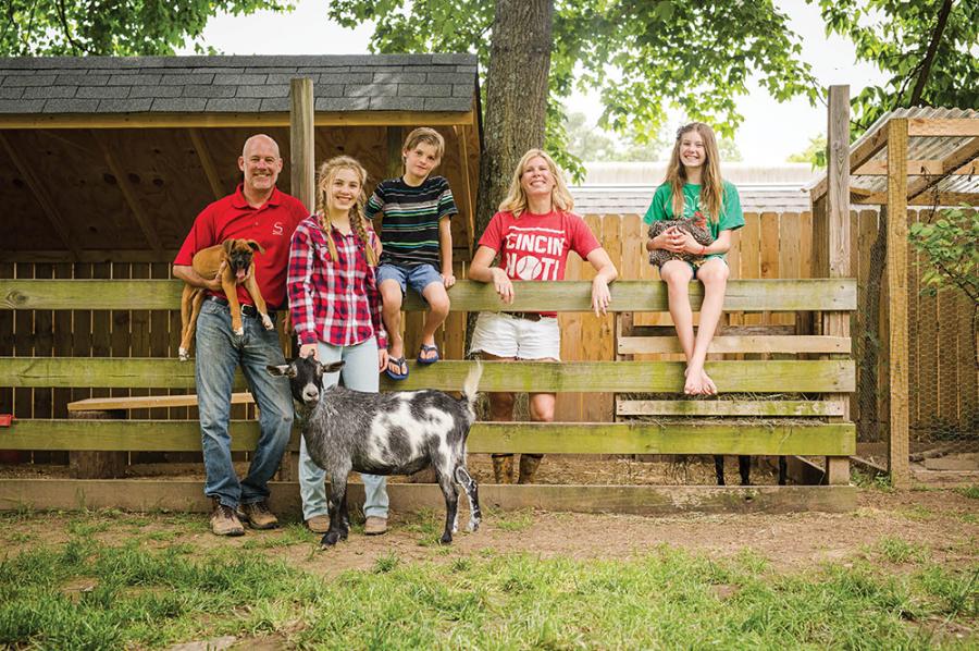 (Clockwise from top) The Slusher family—from left, Clay, Avery, Peyton, Erika, and Grayson—with Casper (the friendly goat!), the pup, and a chicken