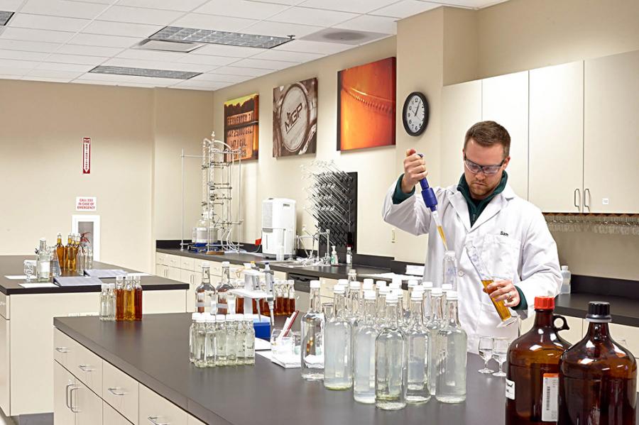 Lab Technician Sam Schmeltzer takes a sample