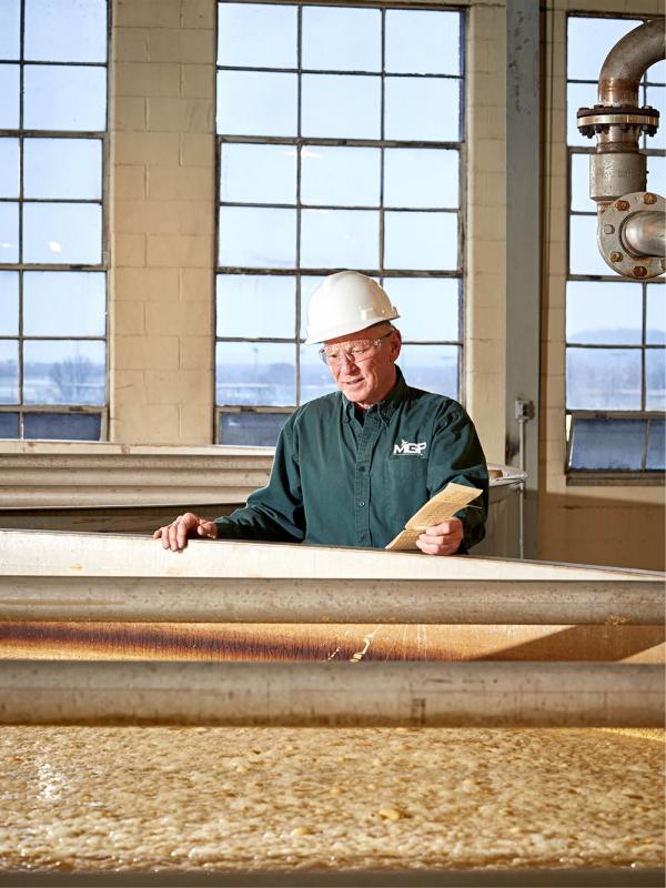  El Destilador Maestro Greg Metze comprueba un tanque lleno de puré de fermentación 